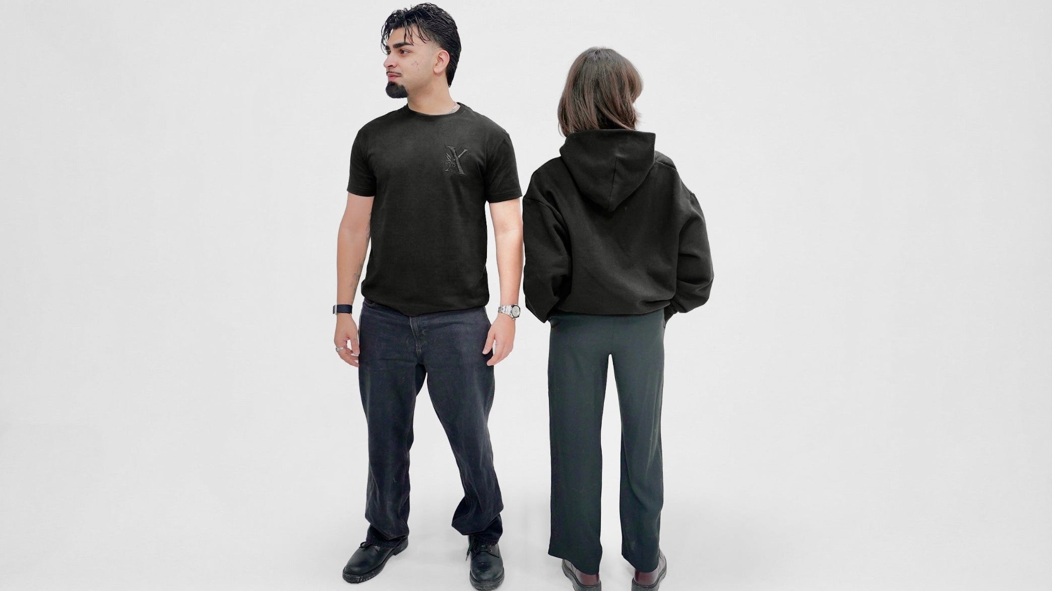 Two people wearing black t-shirt and hoodie on a white background